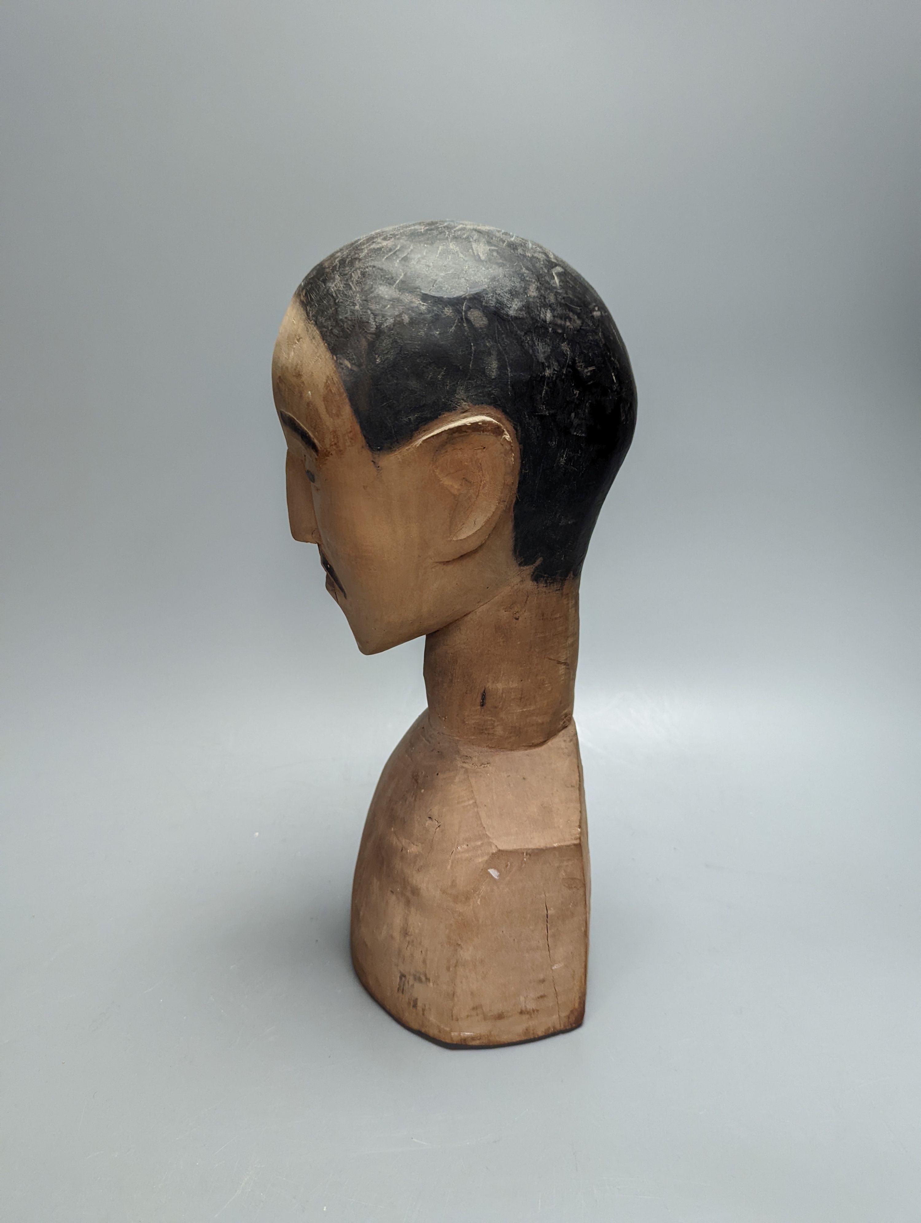 An unusual early 20th century South East Asian carved wood bust, height 30cm